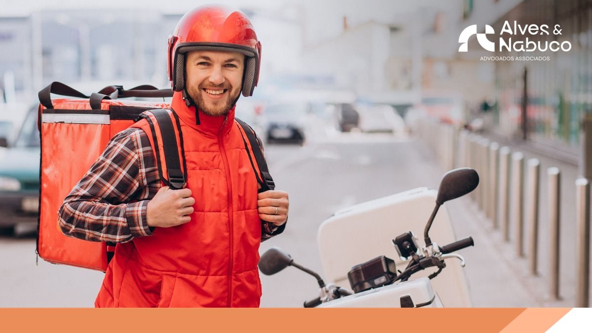 Entregador de capacete e mochila térmica ao lado da moto, em uma rua da cidade